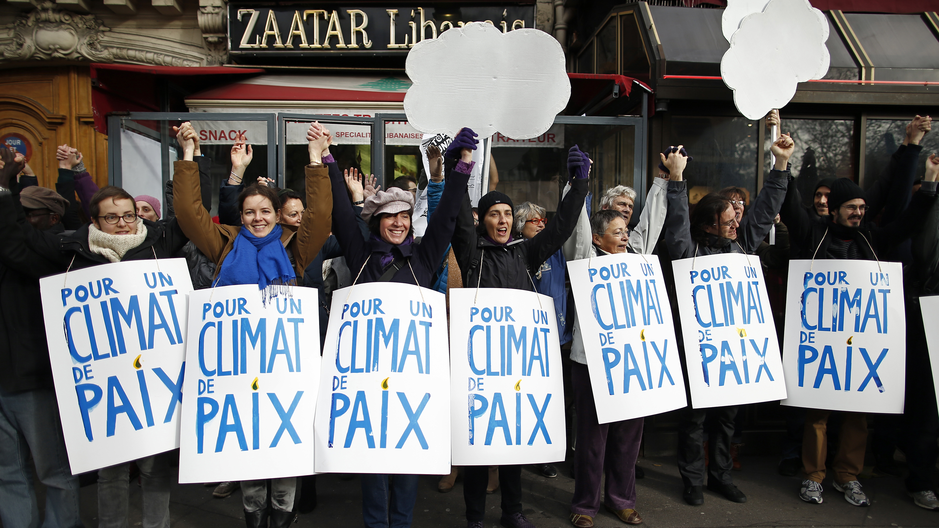 Climate activists formed a 2-mile human chain Sunday along Parisian sidewalks after authorities banned a full-fledged climate march following the Nov. 13 attacks in the French capital. Demonstrators said they were determined to find ways to express their